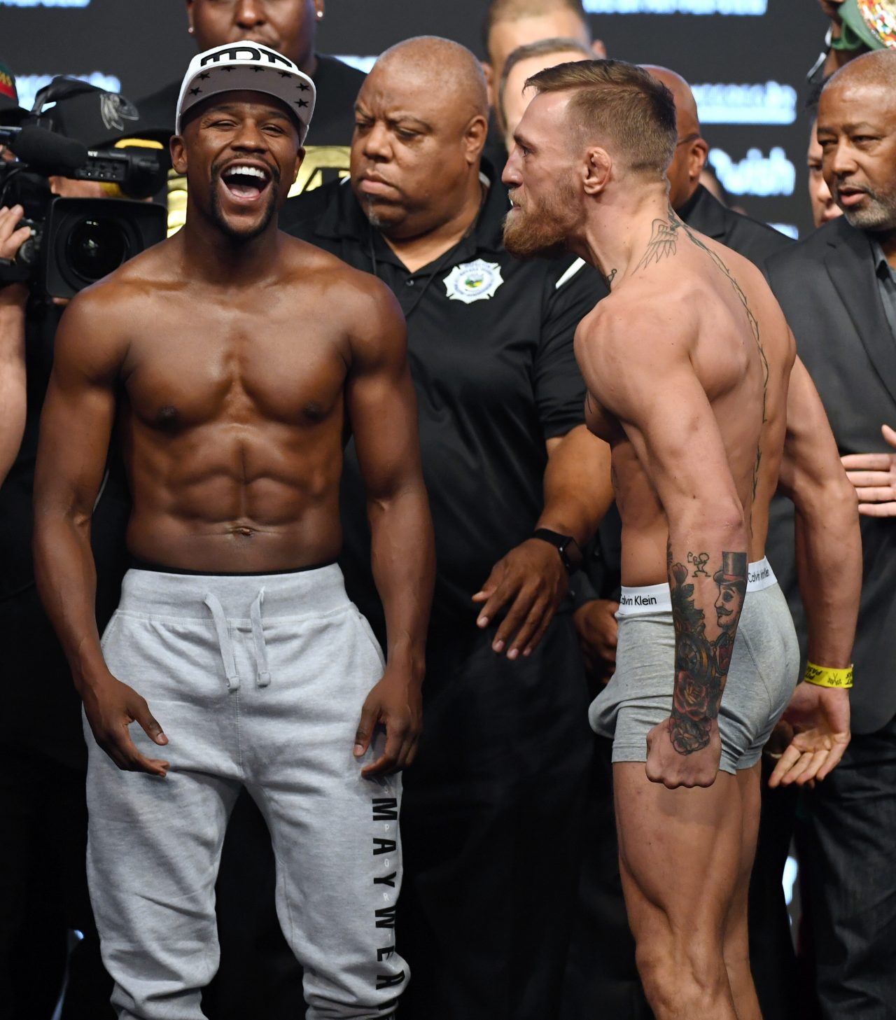 LAS VEGAS, NV - AUGUST 25:  Boxer Floyd Mayweather Jr. (L) laughs after facing off with UFC lightweight champion Conor McGregor during their official weigh-in at T-Mobile Arena on August 25, 2017 in Las Vegas, Nevada. The two will meet in a super welterweight boxing match at T-Mobile Arena on August 26.  (Photo by Ethan Miller/Getty Images)