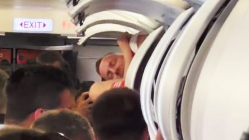 WATCH: Stag do lad crawls out of plane’s overhead luggage compartment in full Arsenal FC kit